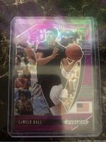 Front of LaMelo Ball Prizm rookie card showing player image, purple wave holographic design, RC logo, and Panini Prizm branding.