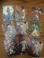 Photo showing nine Fleer Metal baseball cards with players in various poses including batting, pitching and fielding with holographic and shiny patterns