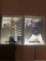 Two Topps Finest baseball rookie cards, Manny Machado in Baltimore Orioles uniform and Nolan Arenado in Colorado Rockies uniform, both in plastic protective sleeves.