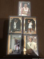 Full view of all five rookie cards on a brown surface.