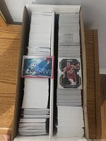 Two boxes filled with over 1600 stacked sports cards including NBA and NFL players visible on top cards.