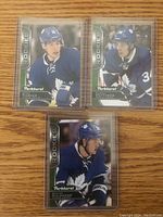 Three Toronto Maple Leafs NHL Upper Deck Parkhurst rookie cards featuring Mitch Marner, Auston Matthews, and William Nylander, all in protective sleeves.
