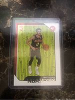 Front view of Trae Young rookie card showing player in Atlanta Hawks jersey with green background and NBA Hoops logo.