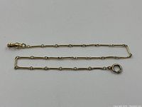 Full length of chain laid flat showing alternating tube and bead links