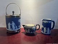 Front view of cobalt blue biscuit barrel, creamer and water pitcher on tabletop