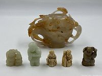 Ornate carved jade teapot center with five carved figurines in front