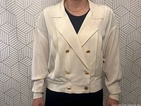 Front view of cream double-breasted jacket on model