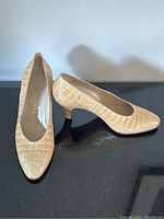 Pair of beige crocodile leather Chanel pumps side by side