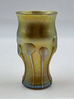Front view of gold iridescent glass vase with applied drip motifs