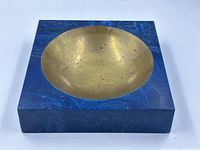 Front view of square block showing round brass bowl inset in blue resin