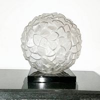 Front view of frosted and clear glass globe on black lacquered base against white background
