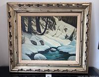 Full view of framed oil painting showing snowy landscape over stream