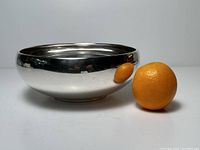 Side view of bowl with orange next to it for scale