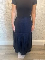 Front view of dark blue linen pleated skirt on model