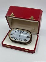 Desk clock displayed in open red Cartier box showing overall appearance