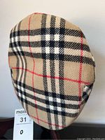 Top and side view of flat cap showing overall Burberry plaid pattern and shape.