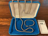 Necklace and bracelet displayed inside blue velvet-lined box