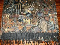 Patterned side showing abstract floral and fan motifs with fringed edge