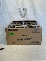 Full box containing 13 individual Capri Collection water goblet glasses in original dividers and packaging.