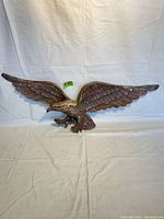 Front view of large brass American eagle sculpture with wings fully spread.