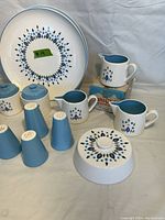Close detail of portion of the lot showing creamers, shakers, covered dish, and plate with floral pattern