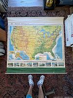 Full view of the large vintage Rand McNally school map of the United States hung on wall showing entire map area from east to west coast including southern states and part of Canada above.