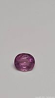 Close-up top view of the pink oval sapphire showing color, cut, and clarity details.