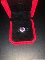 Amethyst ring in sterling silver set in a red velvet jewelry box with black interior.