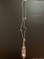 Full view of the sterling silver necklace with pendant on black background.