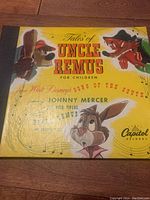 Close-up of one album cover titled 'Tales of Uncle Remus - For Children' with characters and musical notes, in yellow background with signs of wear on surface.