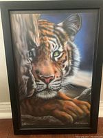 Framed painting of a tiger with detailed fur and whiskers, showing the airbrush technique and brush strokes.