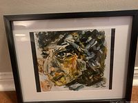 Front view of the framed painting showing the abstract human face with cubist elements and mixed colors.
