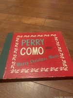 Front cover of Perry Como Merry Christmas Music multi-album set in red and green with white decorative border.