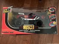 Front view of the New Bright Monster Muscle Pontiac GTO remote control monster truck in original box, showing bright red and black color scheme and large wheels.