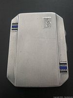 Front view showing guilloche finish, NS monogram, enamel corner stripes