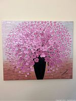 Original canvas painting of a bouquet of clustered bright pink flowers in a tall black vase, hanging on a wall, displaying signature and color gradients.