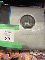 Front cover of Disney World Memories photo album showing metal castle emblem and the word 'MEMORIES'