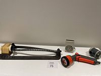 Full lot including sprinkler, timers, and hose spray head arranged on white table against gray wall