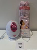 Front view showing white facial steamer with pink nozzle and packaged TheraWell body wrap