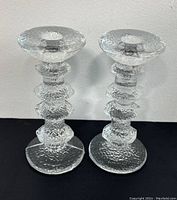 Front view of both clear glass candle holders showing texture and shape.