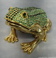 Side view of gold-tone frog trinket box showing crystal embellishments and detailed legs.