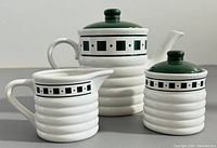 All three pieces of the coffee set: coffee pot, creamer, and sugar bowl with matching decorative bands and green lids/knobs.