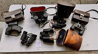Overview of all binoculars and cases laid out on table showing quantity and condition