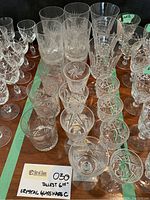 Top view showing the full set of multiple crystal glasses on a wooden surface including highball, tall liqueur, small liqueur, and wine glasses.