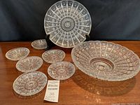 Overview of all eight pieces including centerpiece bowl, serving plate on stand, and six small dishes arranged on table