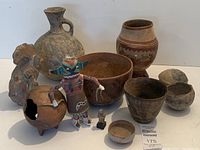 Overview of entire lot showing Kachina doll, pottery vessels and figurines
