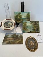 Group view showing three landscape paintings, oval cherub print and oval portrait