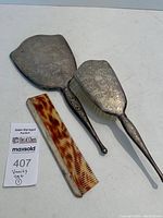 Full view of the vanity set including hand mirror, hairbrush, and comb on white background.