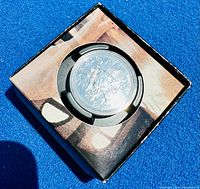 Sterling silver coin sealed in black and beige packaging from the Canada Mint, showing the obverse design with maple leaf.
