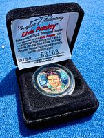 Colorized Elvis Presley quarter in black velvet presentation box with Certificate of Authenticity behind it